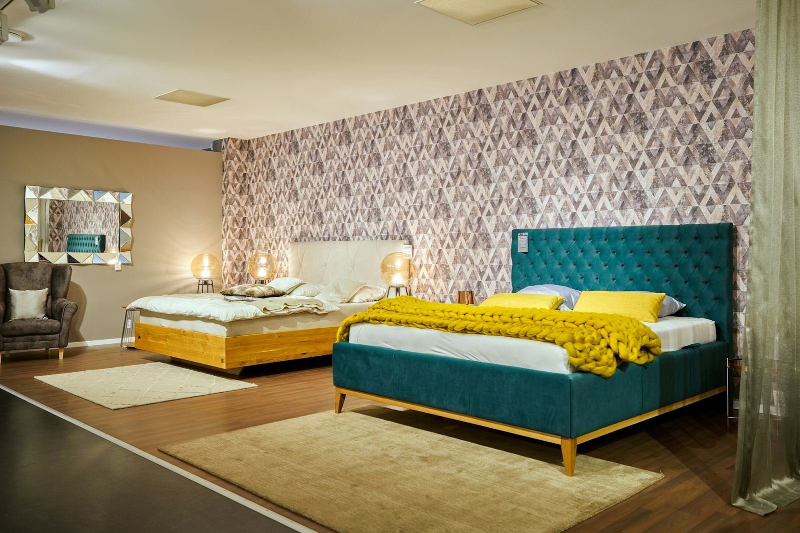 A bedroom with a teal velvet bed and yellow throw